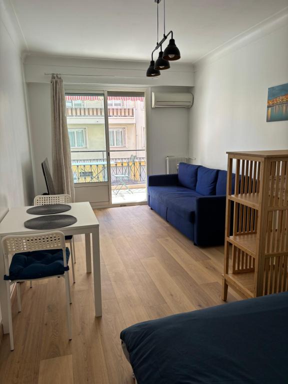 un salon avec un canapé bleu et une table dans l'établissement Studio 2 étoiles à Menton pour 4 personnes, à Menton