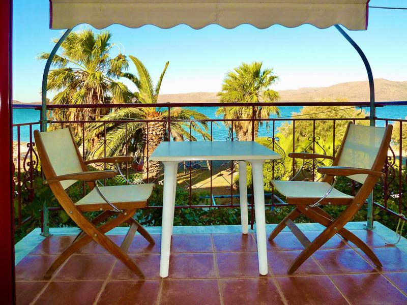 een tafel en stoelen op een balkon met uitzicht op de oceaan bij Lefteris in Polichnítos