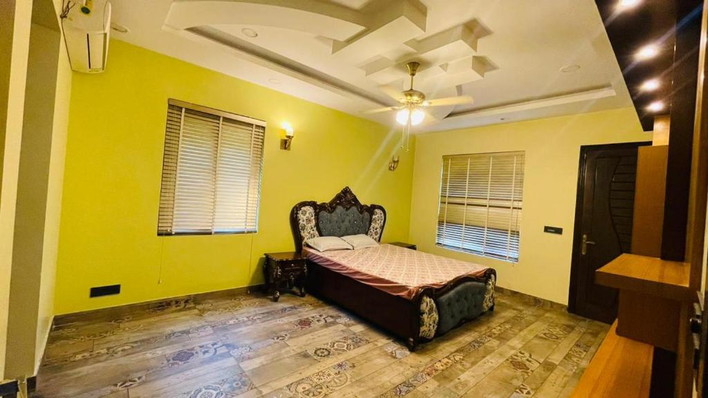 1 dormitorio con 1 cama en una habitación amarilla en Shashi Farms for pool parties and stays, en Gurgaon