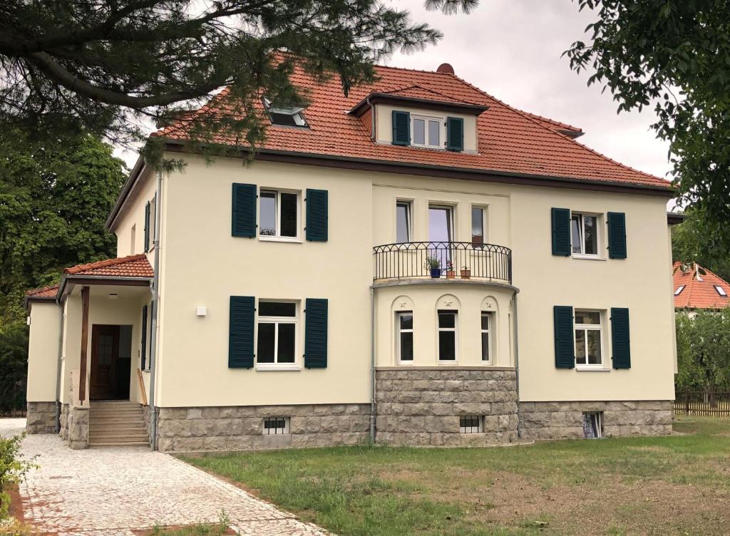 ein großes weißes Haus mit rotem Dach in der Unterkunft Villa Buchholz in Arnstadt