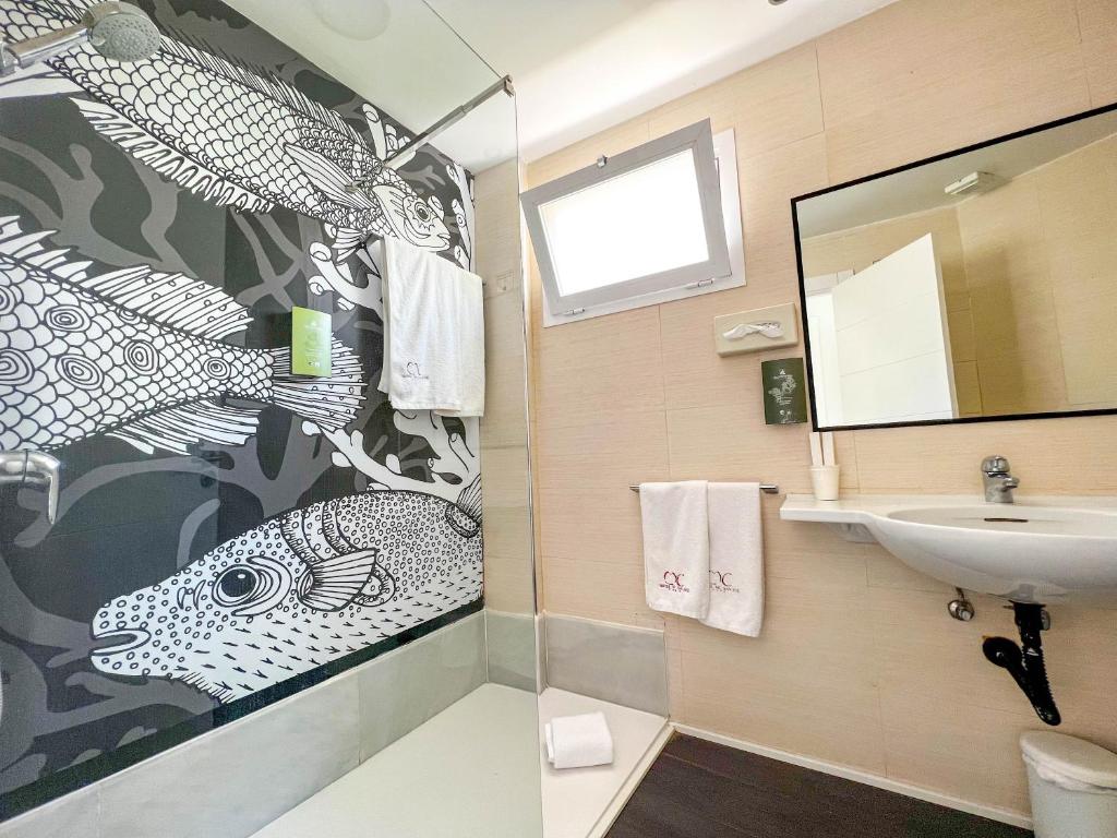 a bathroom with a sink and a fish painting on the wall at Hotel MC San José in San José