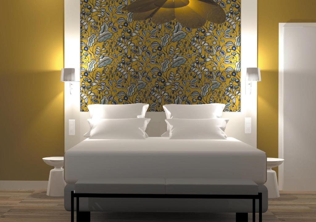 um quarto com uma cama com um quadro na parede em Gabriel Hotel Chinon em Chinon