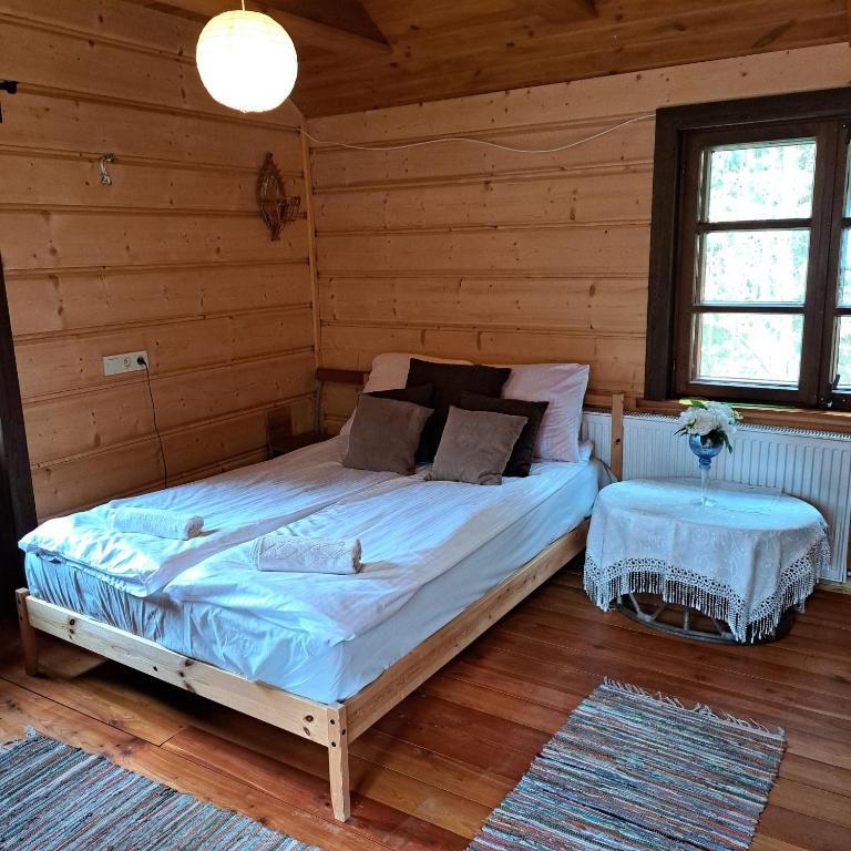 1 dormitorio con 1 cama en una cabaña de madera en Domek wycieczkowy 