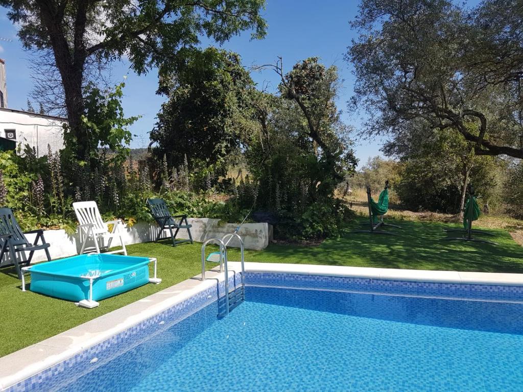 a swimming pool in a yard next to a house at Casa de la Fuente in Almonaster la Real