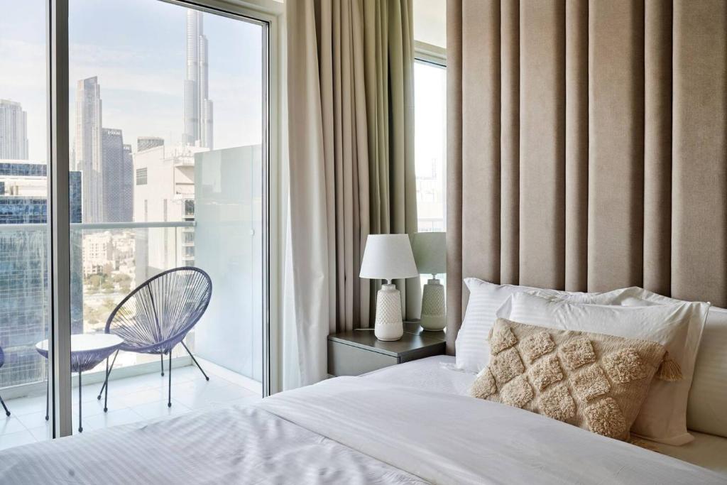 a bedroom with a bed and a large window at Burj Khalifa View With 5star Flatwalk Dubai Mall in Dubai