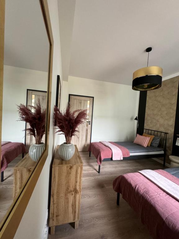 a bedroom with two beds and a mirror at Apartament Pileckiego 7b/37 in Suwałki