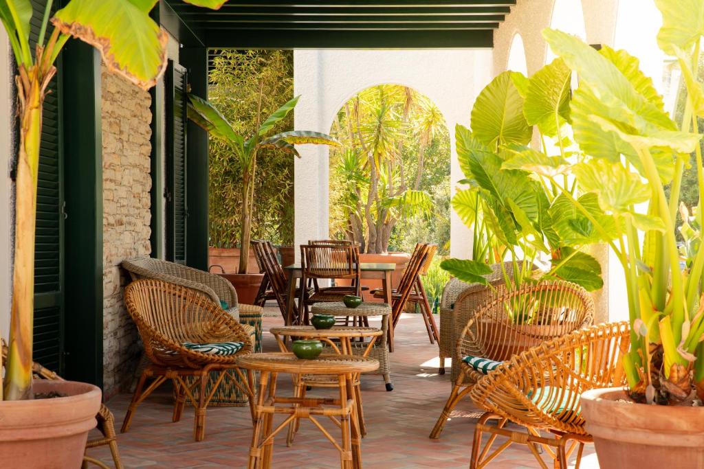 un patio al aire libre con sillas, mesas y plantas en California Park Hotel en Forte dei Marmi