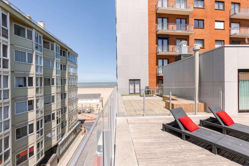 - un balcon avec 2 oreillers rouges dans un bâtiment dans l'établissement Sunny apartment in Knokke-Heist with big terrace, à Knokke-Heist