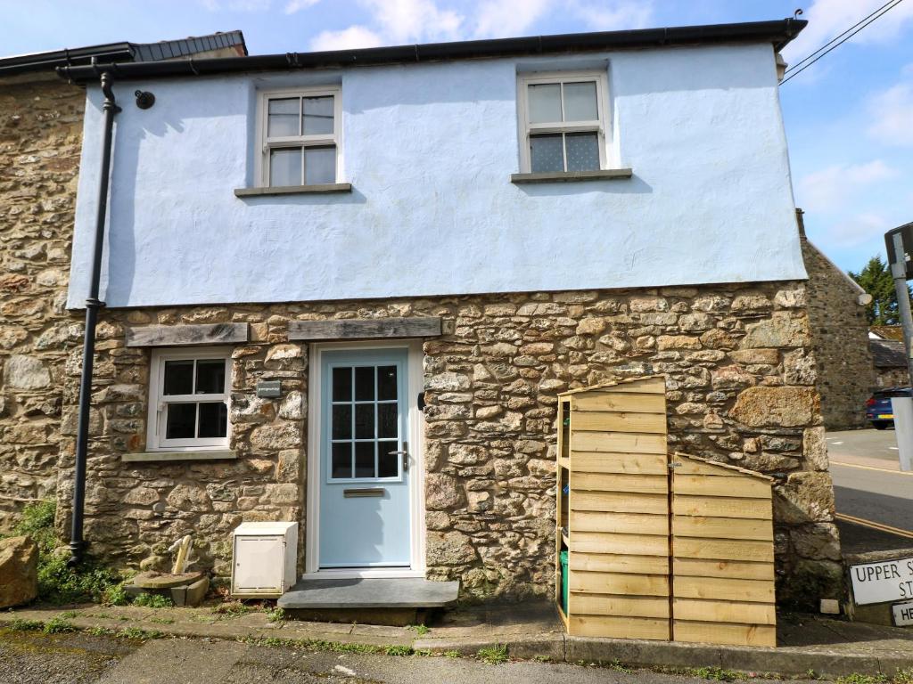 an old stone house with a blue door at Penpwmp in Newport