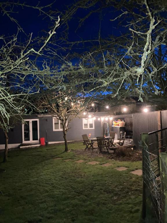 a house lit up at night with lights at Waen las Cabin in Denbigh
