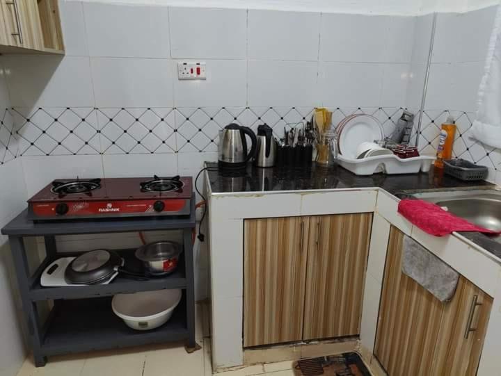 a small kitchen with a stove and a sink at Mely homes in Ruiru