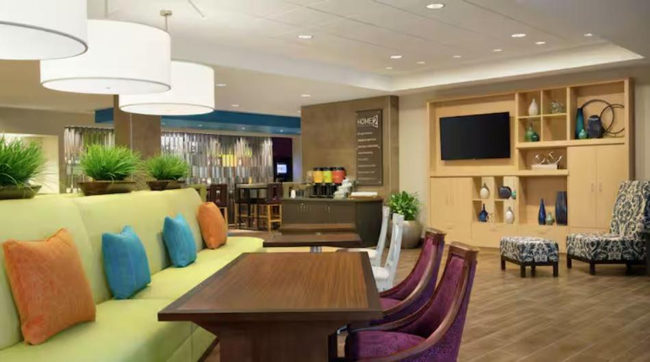 a living room with a couch and a table and chairs at Home2 Suites By Hilton Virginia Beach Princess Anne in Virginia Beach