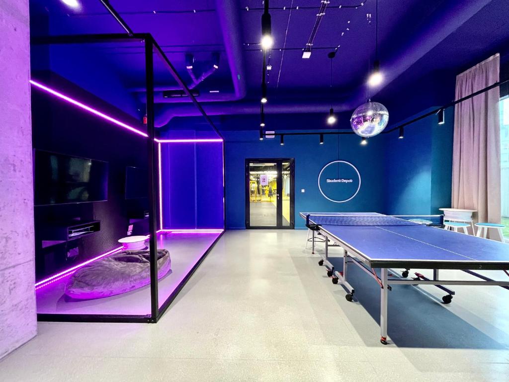 a ping pong table in a room with purple lighting at Chillout Dorm Cracow by BookingHost in Krakow
