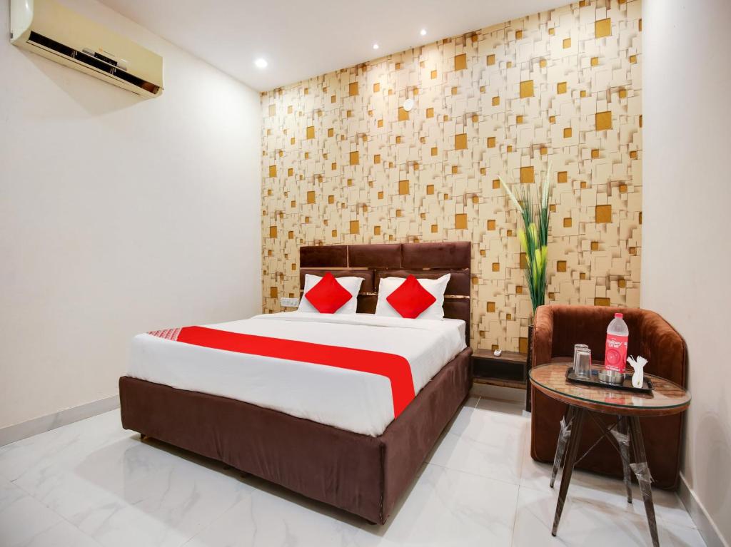 una camera con un grande letto e un tavolo di OYO Flagship Golden A a Ludhiana
