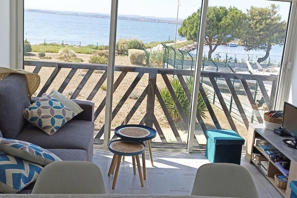 un salon avec un canapé et une vue sur l'océan dans l'établissement La lagune plein écran, à Sète