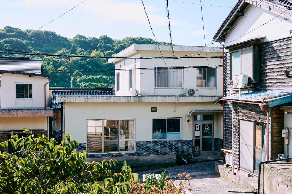 uma casa branca com uma porta num grupo de casas em Aoyado - Tottori Aoya em Tottori