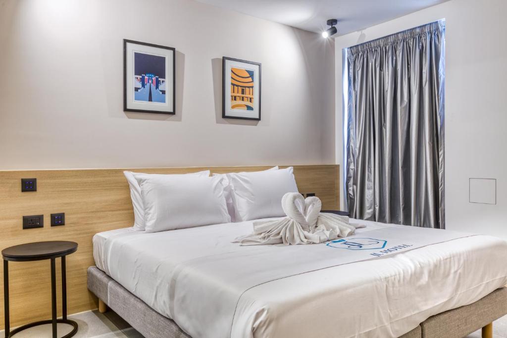 1 dormitorio con 1 cama blanca grande y ventana en JL Hotel, en San Julián