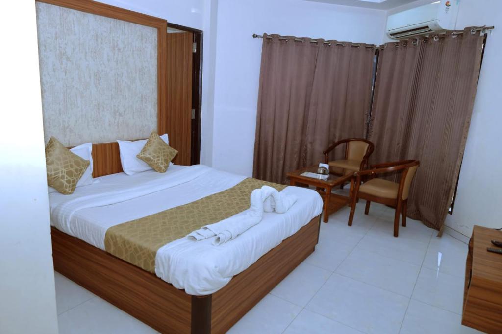 a bedroom with a bed with towels on it at Kings Resort in Silvassa