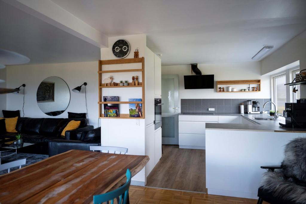 eine Küche und ein Wohnzimmer mit einem Tisch im Zimmer in der Unterkunft The Old Sherrif's House - Family Friendly - Beach in Sandur