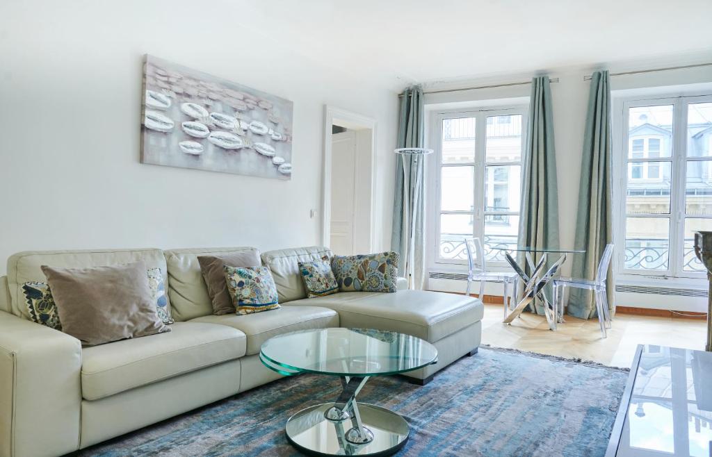 un salon avec un canapé et une table dans l'établissement Elysée/Fg St Honoré- 2 piéces de luxe, à Paris