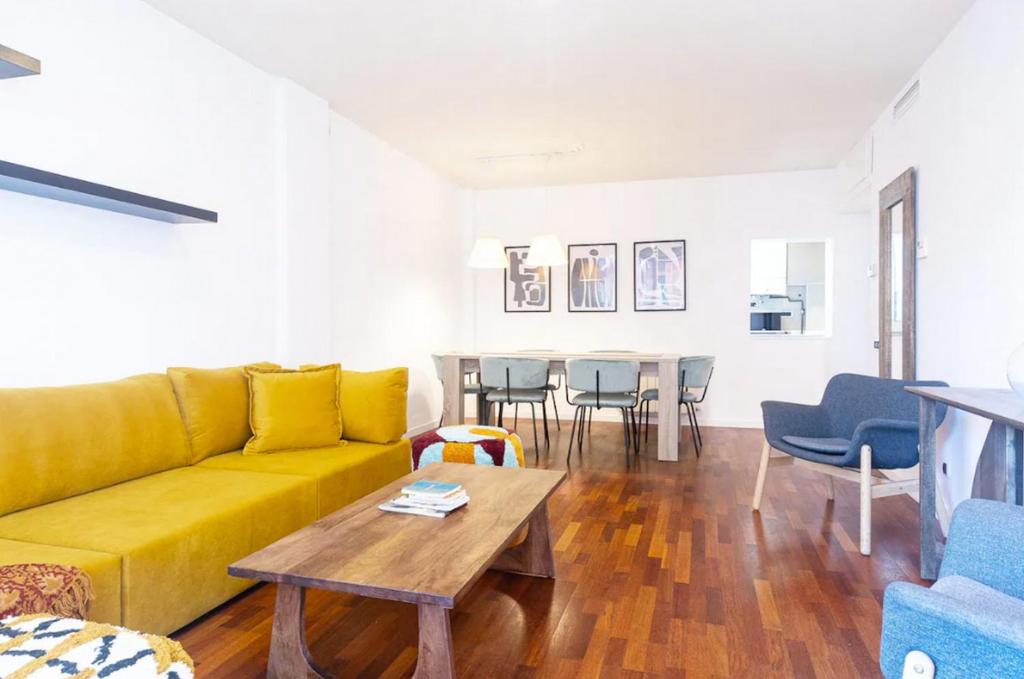 - un salon avec un canapé jaune et une table dans l'établissement Appartamento a Cremona con WI-FI, à Crémone