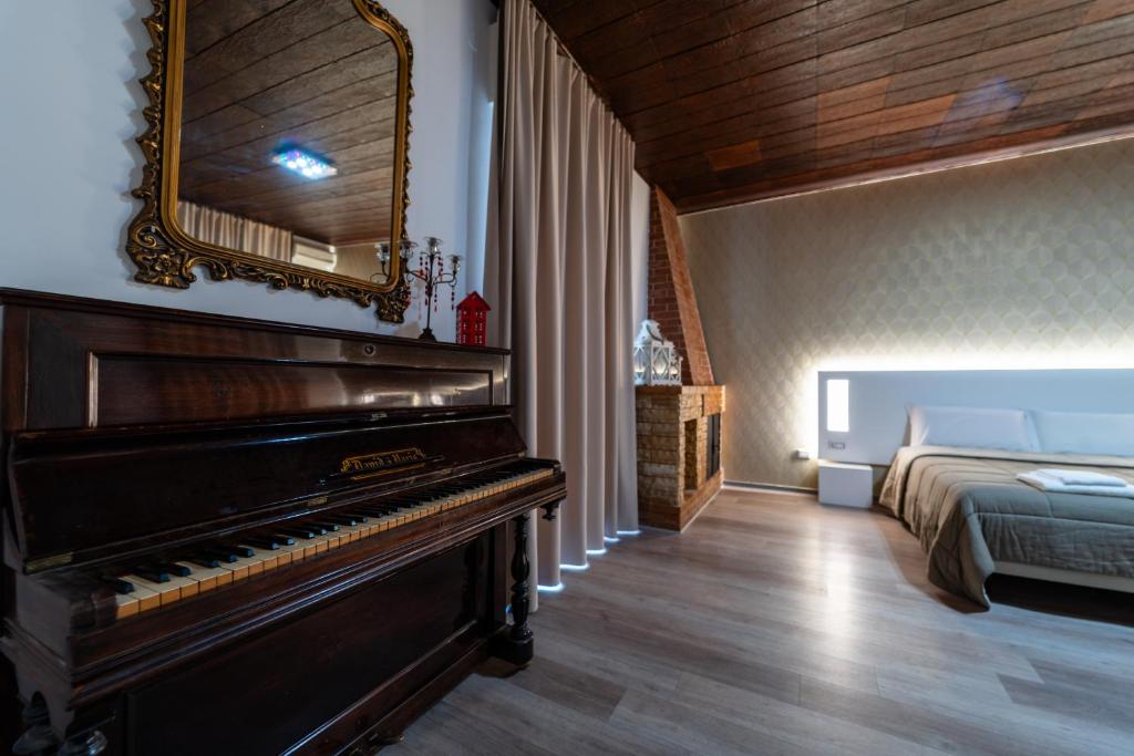 1 dormitorio con piano y 1 cama con espejo en Alta Dimora, en Bitritto