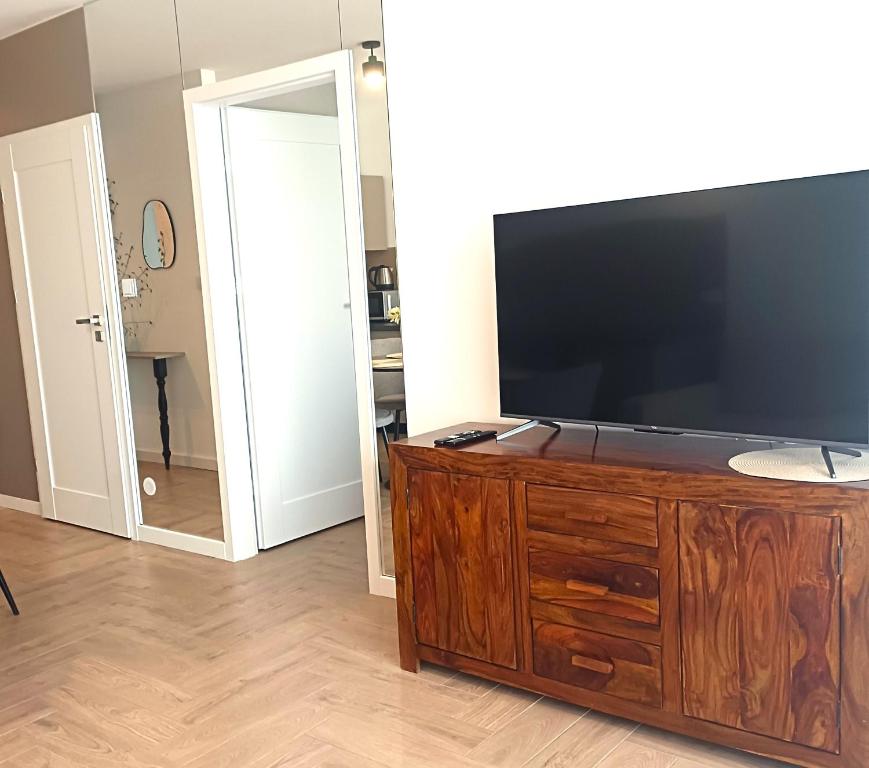 een woonkamer met een grote flatscreen-tv op een houten dressoir bij NOWY Apartament Bitwy Warszawskiej in Siedlce
