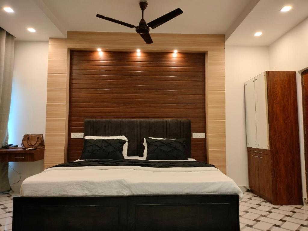 a bedroom with a large bed with a ceiling fan at Kollolini Kolkata in Kolkata