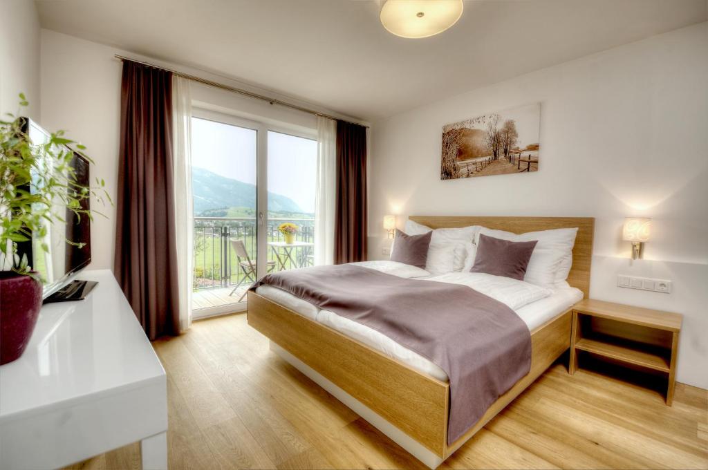 a bedroom with a bed and a large window at dasLichtenberg westside in Saalfelden am Steinernen Meer