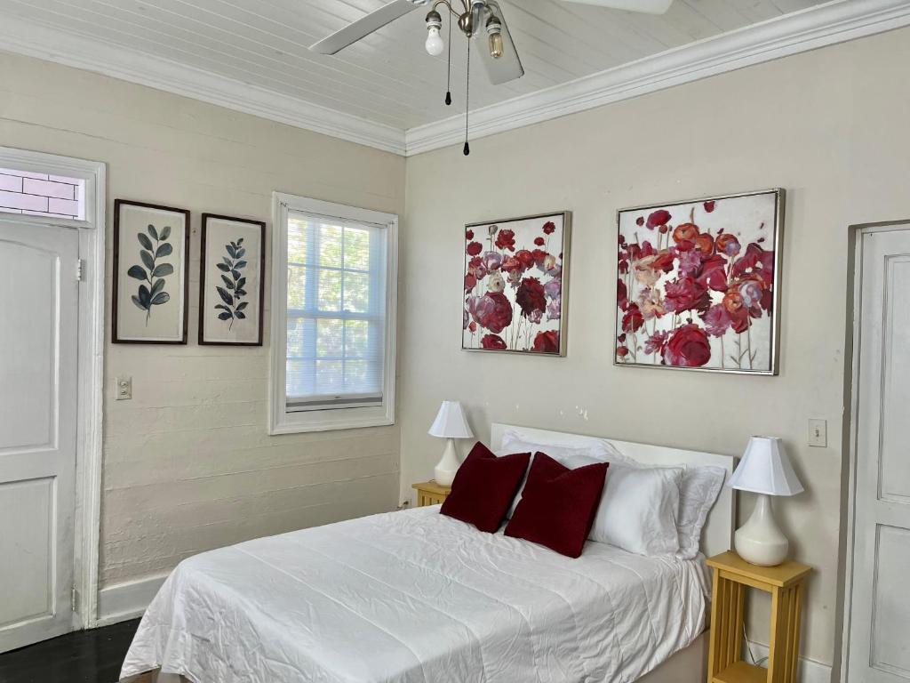 a bedroom with a white bed with red pillows at Downtown Nassau Oasis Unit 2 in Nassau