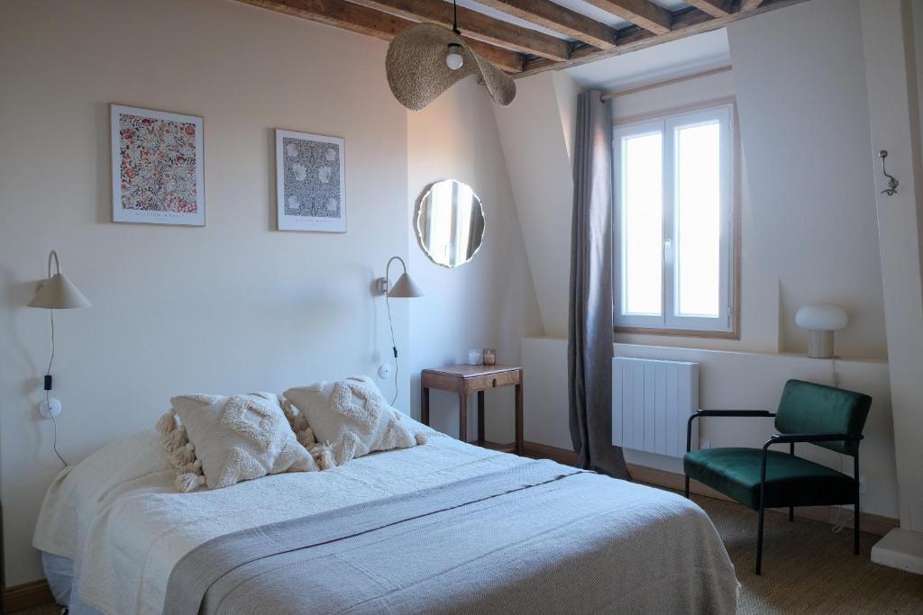 ein Schlafzimmer mit einem Bett, einem Stuhl und einem Fenster in der Unterkunft Villa Juliette - Plage et falaises en famille in Le Tréport