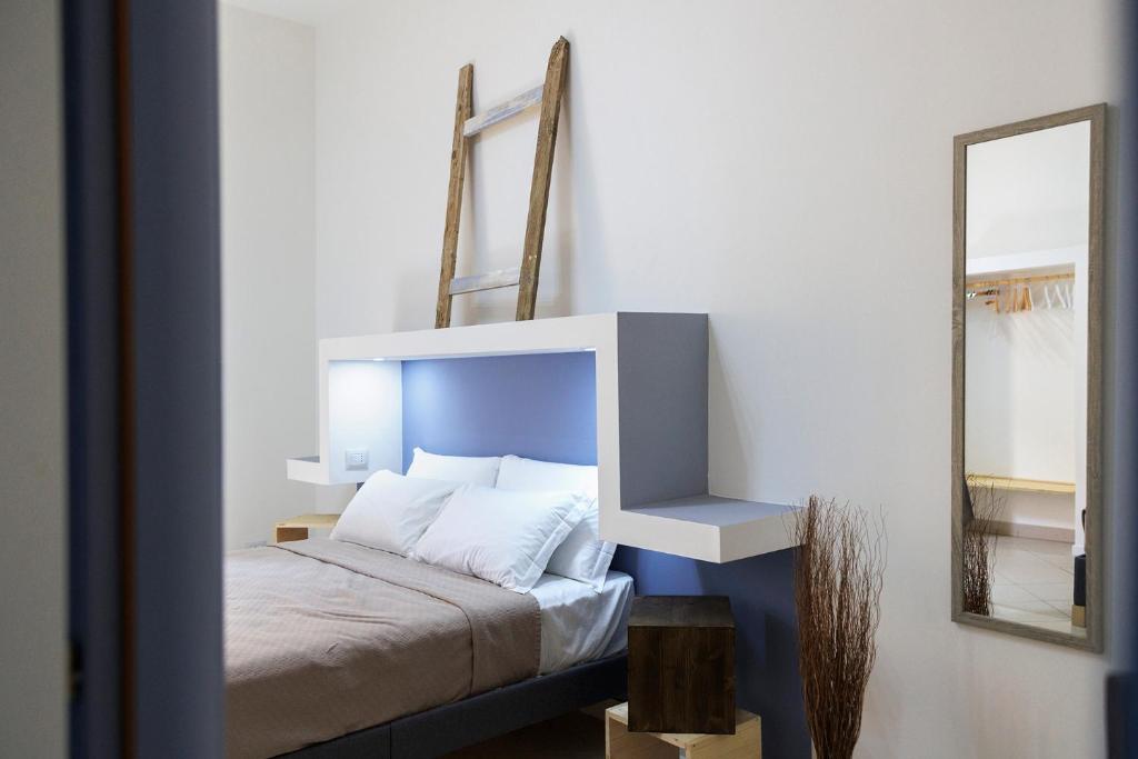 a bedroom with a bed with a blue headboard and a mirror at Elsa d'Ortigia in Siracusa