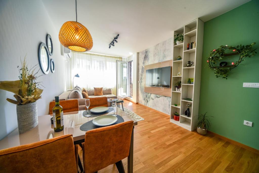 ein Wohnzimmer mit einem Tisch und einer grünen Wand in der Unterkunft BAGDALA RESIDENCE APARTMAN in Kruševac