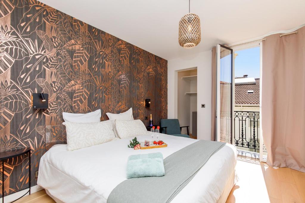 - une chambre avec un grand lit blanc et un mur dans l'établissement 06AG - Bel appartement proche Palais des Festivals, à Cannes