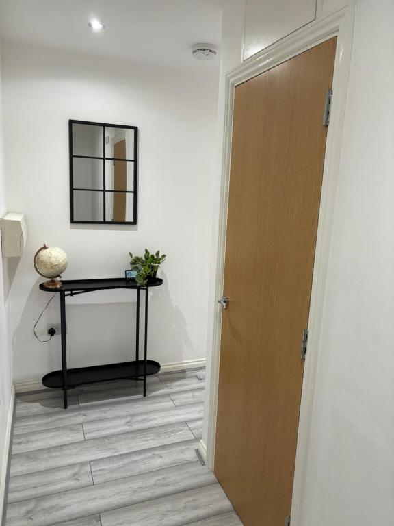 a door leading to a hallway with a table and a mirror at Spacious Retreat with Parking: Ideal for Families & Contractors in York