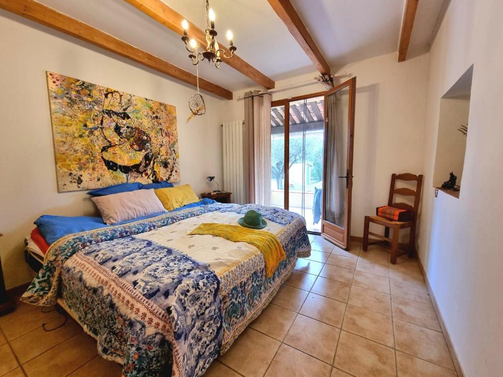 a bedroom with a bed and a painting on the wall at La Maison de Blu in Lorgues