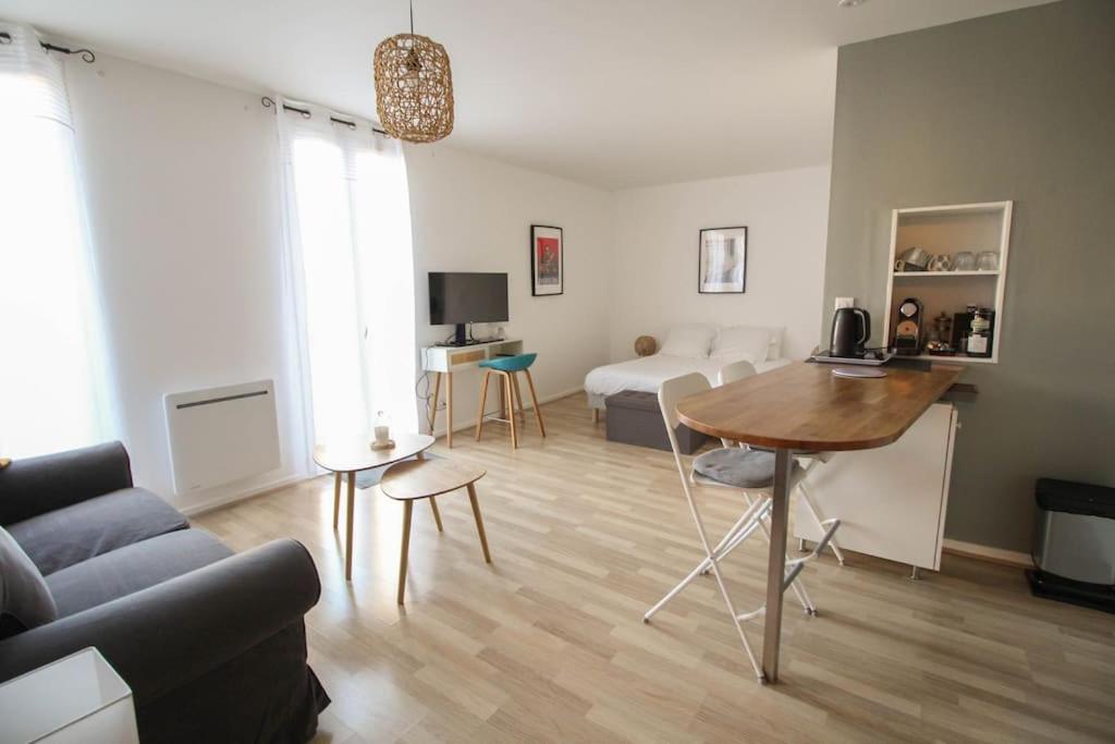 a living room with a table and a couch at Le St Ausone : Studio Centre Ville/parking in Angoulême