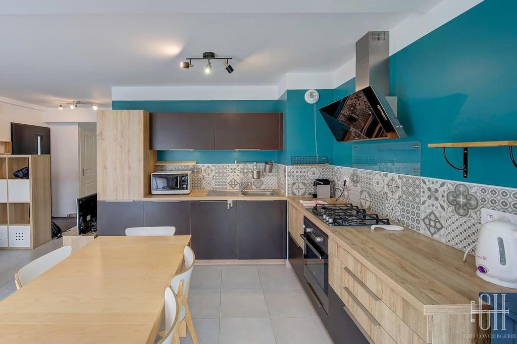 eine Küche mit blauen Wänden und einer hölzernen Arbeitsplatte in der Unterkunft Le Passiflore / Hôpital Vinci in Chambray-lès-Tours