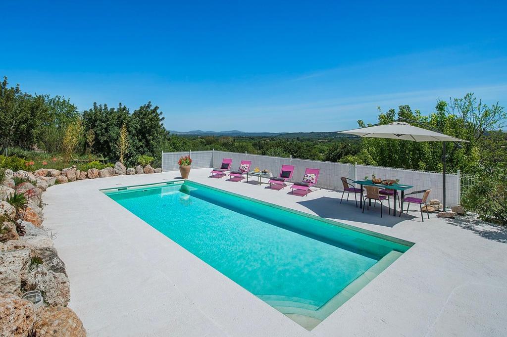 een zwembad in een achtertuin met een tafel en stoelen bij Sa Fontasa in Moscari
