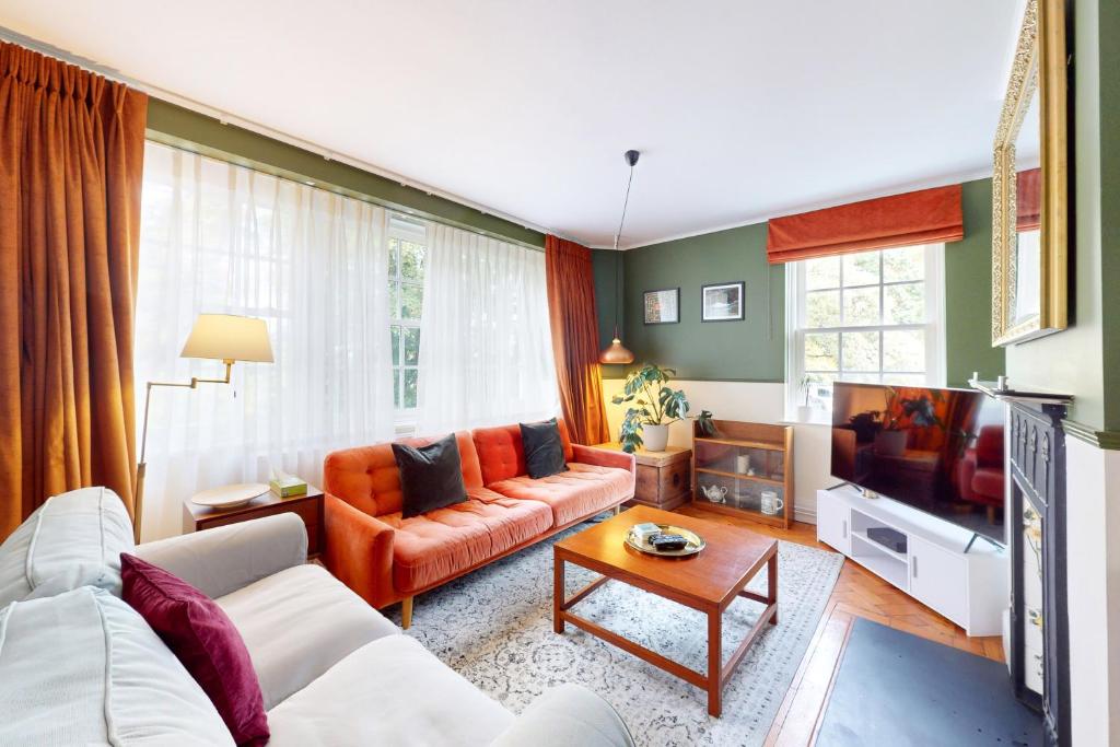 een woonkamer met een bank en een tv bij 3 bedroom Family Friendly Apartment in Hillcrest in Londen