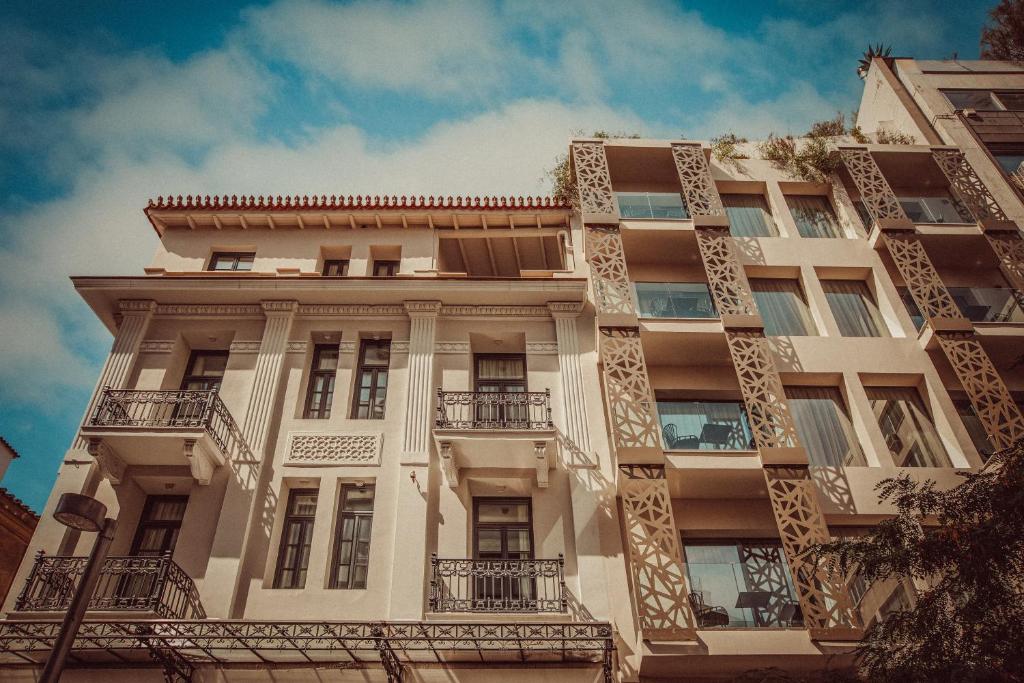 um edifício branco alto com varandas em The Residence Aiolou Hotel & Spa em Atenas