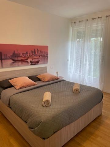 ein Schlafzimmer mit einem großen Bett und einem großen Fenster in der Unterkunft Little Eden by Arcotrilogy-Homes in Arco