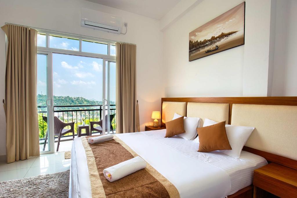 a bedroom with a bed and a large window at Amandara Hills Kandy in Kandy