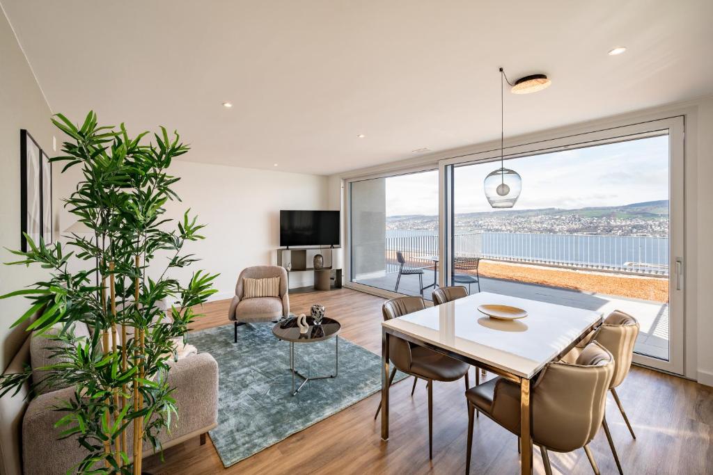 sala de estar con mesa, sillas y ventana grande en aestate living lakeview in Horgen Zürich Zug Pfäffikon, en Horgen