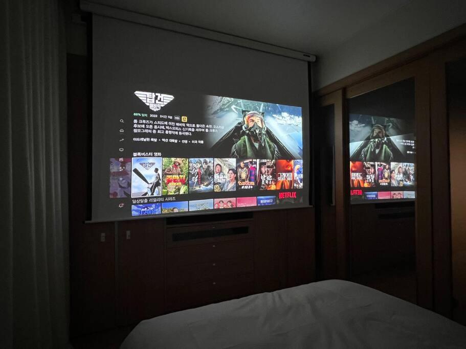 a bedroom with two television screens on a wall at Party Room, 1min to Suwon Rodeo Street in Suwon