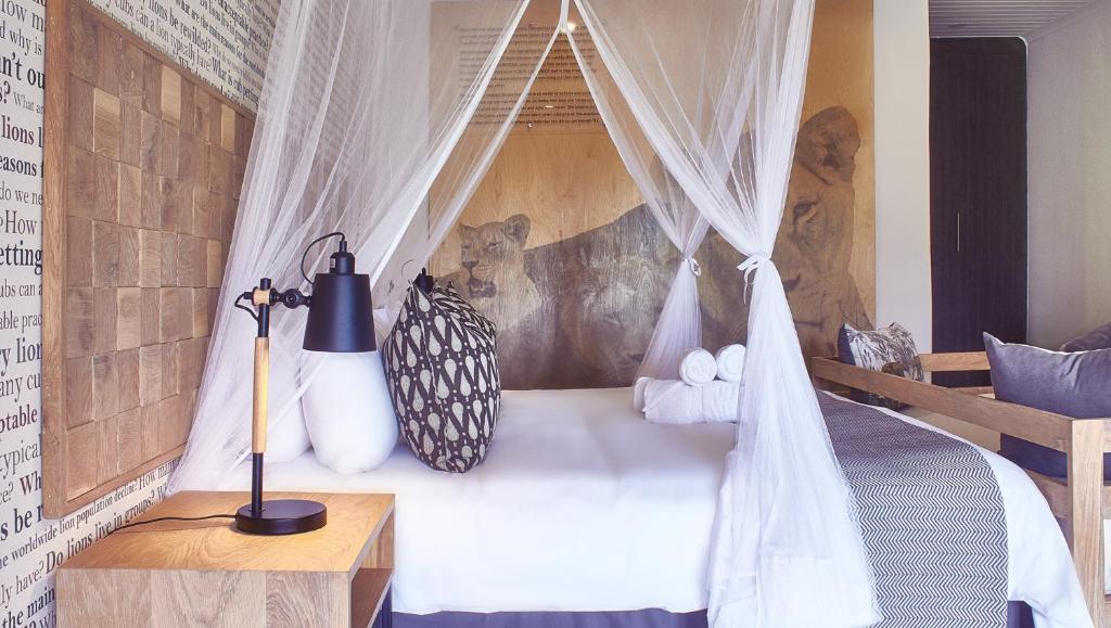 a bedroom with a bed with a mosquito net at LIONSROCK Big Cat Sanctuary in Bethlehem