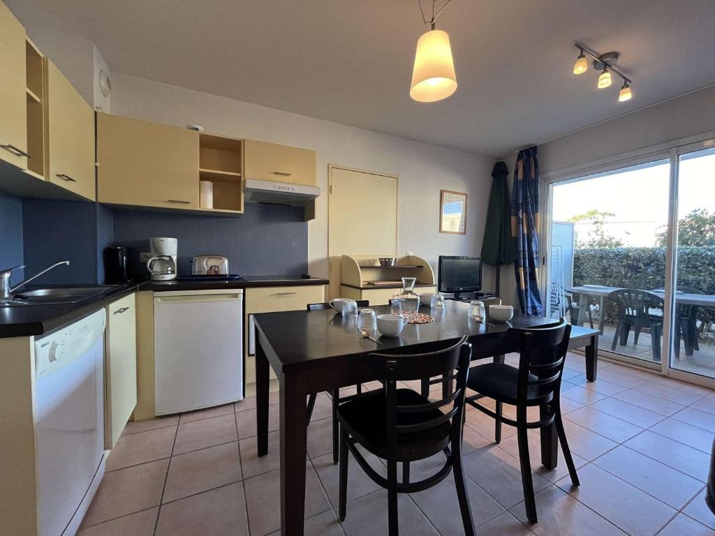 a kitchen and dining room with a table and chairs at Appartement Gruissan, 2 pièces, 4 personnes - FR-1-229-372 in Gruissan