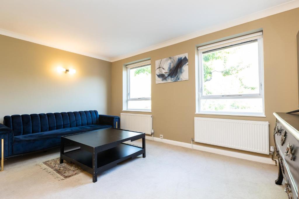 a living room with a blue couch and a table at Wonderful 5 BDR Flat wParking, Maida Vale in London