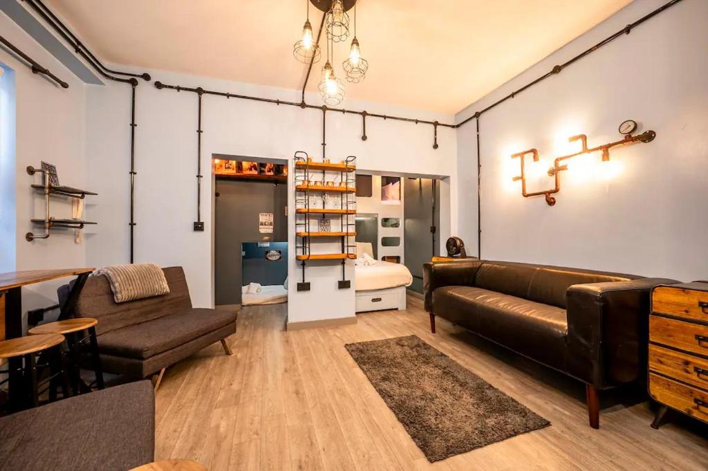 a living room with a couch and a table at Pass the Keys London Industrial studio flat Harry Potter Theme in London