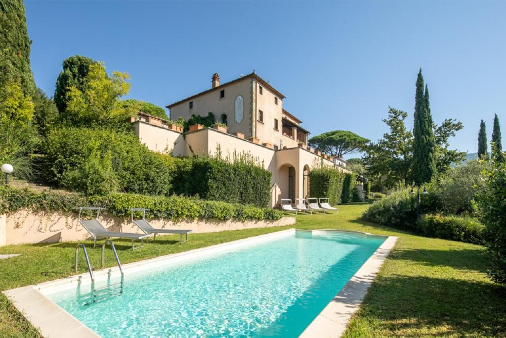 a swimming pool in front of a house at Villa Belforte by VacaVilla in Lamporecchio